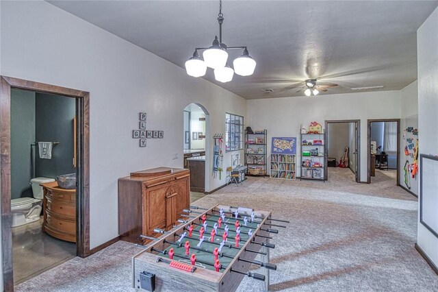 25478 Sooner Ave, Purcell, OK 73080 - playroom with arched walkways, light colored carpet, a ceiling fan, and a chandelier