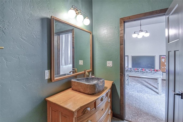 25478 Sooner Ave, Purcell, OK 73080 - bathroom featuring a textured wall, vanity, and a chandelier