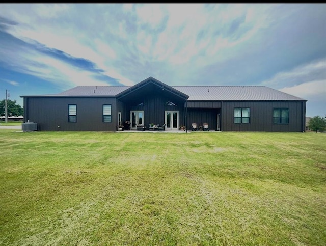 25478 Sooner Ave, Purcell, OK 73080 - rear view of property with board and batten siding, a yard, french doors, and a metal roof