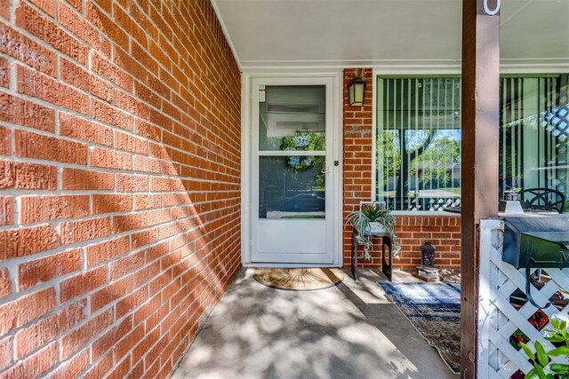 10 Burk Way, Del City, OK 73115 - doorway to property featuring brick siding and covered porch