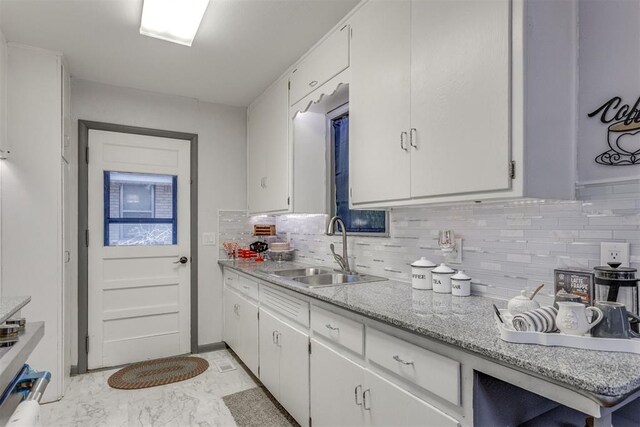 10 Burk Way, Del City, OK 73115 - kitchen with white cabinets, decorative backsplash, marble finish floor, and a sink
