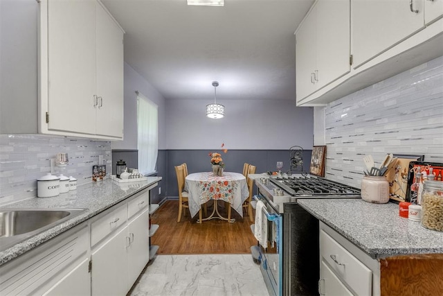 10 Burk Way, Del City, OK 73115 - kitchen featuring stainless steel gas stove, a sink, white cabinetry, and tasteful backsplash
