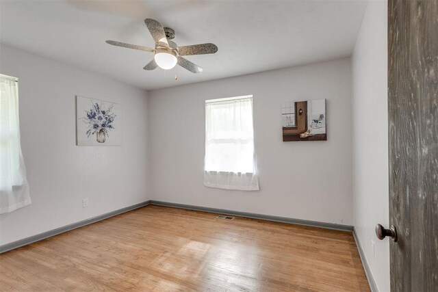 10 Burk Way, Del City, OK 73115 - spare room with baseboards, a ceiling fan, wood finished floors, and visible vents