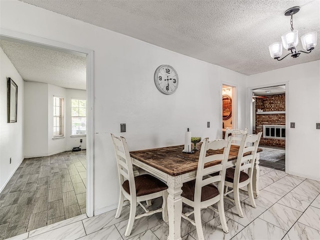 2909 Wheeler Ct, Oklahoma City, OK 73127 - dining space with a fireplace, a textured ceiling, marble finish floor, and an inviting chandelier
