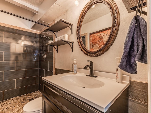 2909 Wheeler Ct, Oklahoma City, OK 73127 - bathroom featuring a textured wall, a tile shower, vanity, and toilet