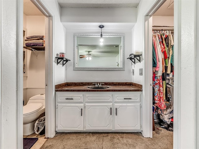 2909 Wheeler Ct, Oklahoma City, OK 73127 - bathroom with a spacious closet, toilet, a ceiling fan, and vanity