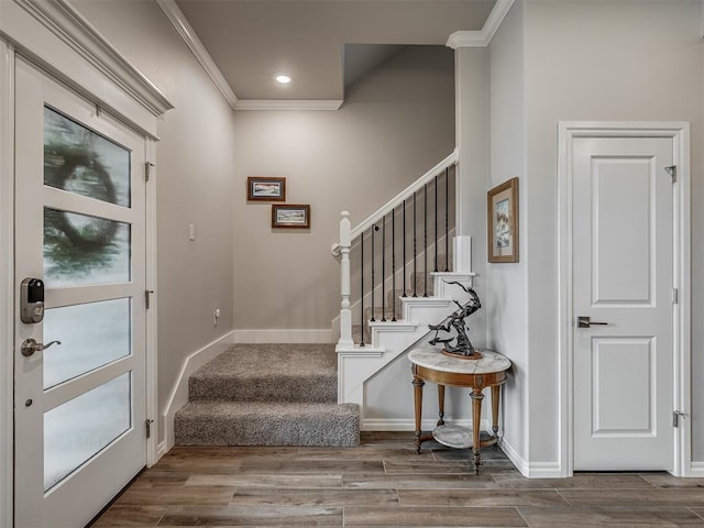 foyer with ornamental molding, stairs, and wood finished floors