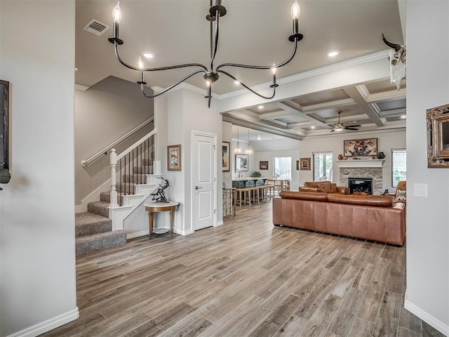living area featuring a ceiling fan, ornamental molding, wood finished floors, and stairway