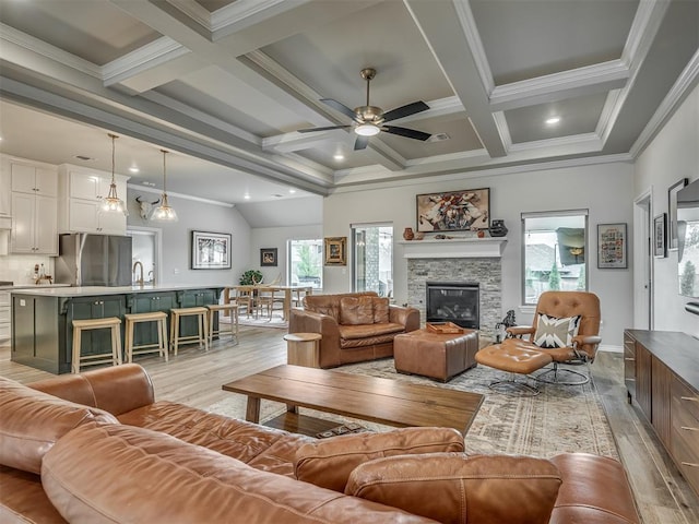 living area featuring plenty of natural light, beam ceiling, and light wood-style floors