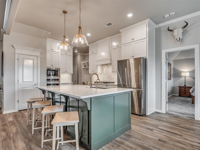 kitchen featuring appliances with stainless steel finishes, baseboards, white cabinetry, and visible vents