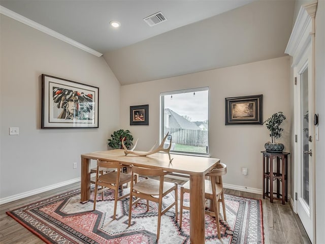 office featuring light wood-style floors, baseboards, ornamental molding, and visible vents