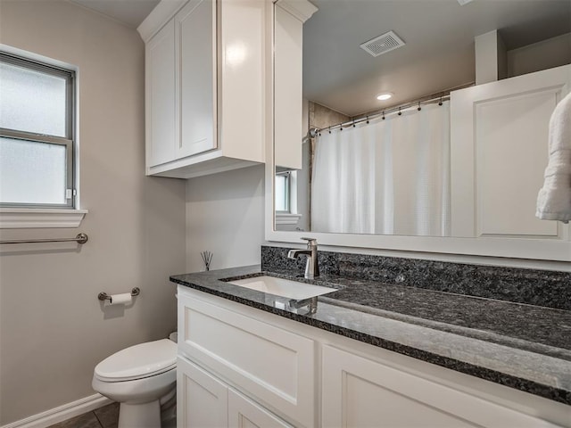 bathroom featuring vanity, toilet, tile patterned floors, baseboards, and visible vents