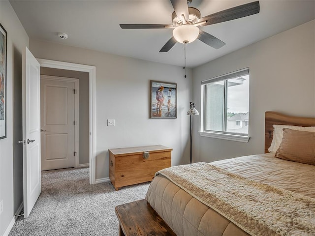 bedroom featuring light colored carpet, baseboards, and ceiling fan