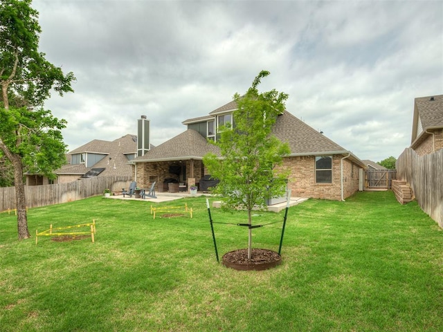 rear view of house featuring a yard, a patio, a shingled roof, and a fenced backyard