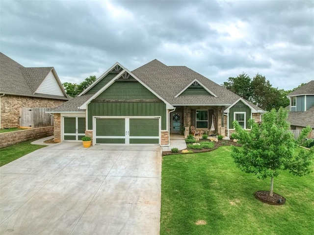 craftsman-style home featuring board and batten siding, driveway, roof with shingles, and a garage