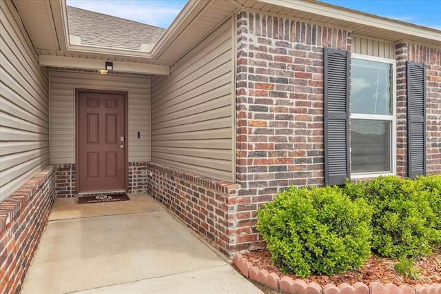 view of exterior entry featuring brick siding