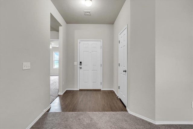 carpeted entrance foyer with visible vents and baseboards