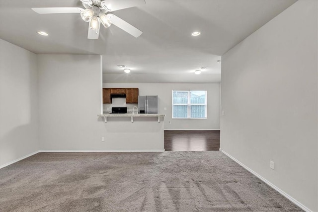 unfurnished living room featuring baseboards, recessed lighting, dark carpet, and a ceiling fan