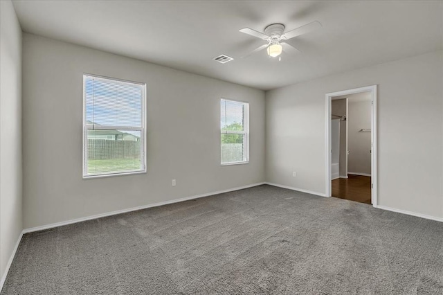 unfurnished bedroom with visible vents, ceiling fan, carpet floors, and baseboards