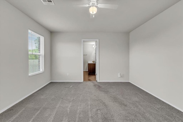 empty room with visible vents, a ceiling fan, carpet flooring, and baseboards