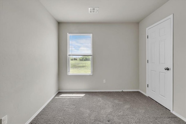 carpeted spare room featuring visible vents and baseboards