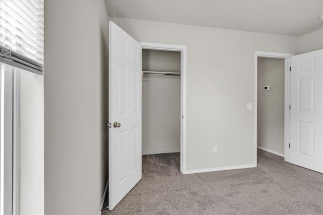 unfurnished bedroom with a closet, carpet, and baseboards