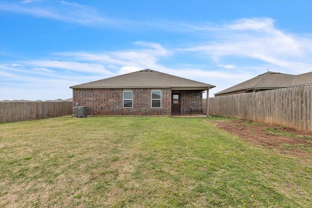 back of house with a patio area, a yard, a fenced backyard, cooling unit, and brick siding