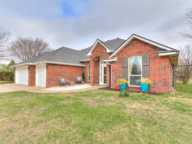 ranch-style house with roof with shingles, driveway, brick siding, an attached garage, and a front yard