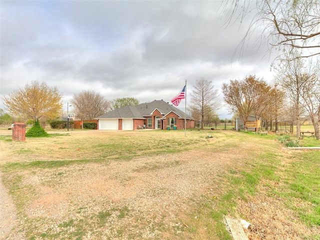 view of front of home featuring an attached garage, driveway, and a front yard