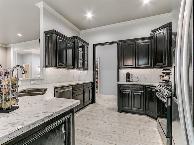 kitchen with appliances with stainless steel finishes, dark cabinetry, and a sink