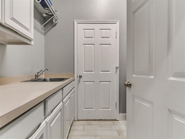 laundry room with a sink and light wood-style floors