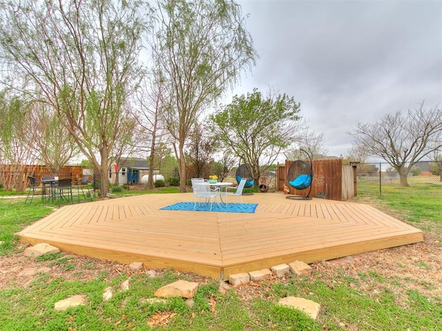 wooden deck with outdoor dining space and a fenced backyard
