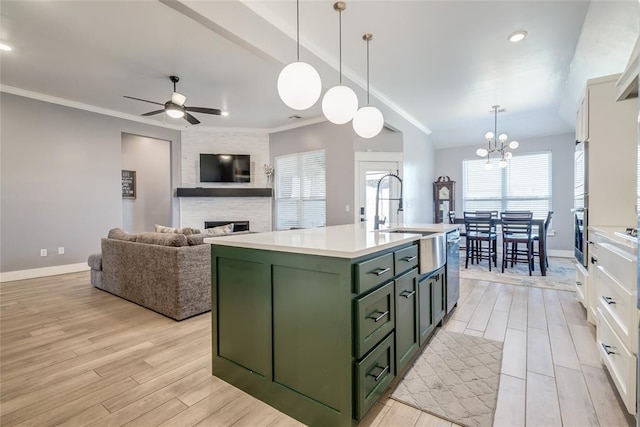 4145 Thunderhead Rd, Norman, OK 73072 - kitchen featuring green cabinets, light wood-style floors, a fireplace, white cabinets, and a ceiling fan