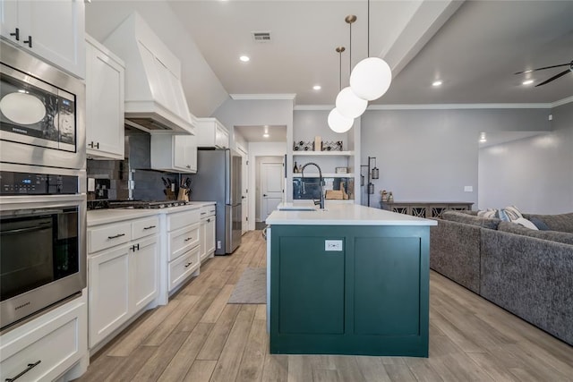 4145 Thunderhead Rd, Norman, OK 73072 - kitchen with stainless steel appliances, crown molding, open floor plan, light countertops, and a center island with sink