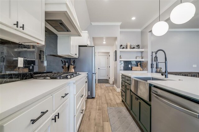 4145 Thunderhead Rd, Norman, OK 73072 - kitchen with appliances with stainless steel finishes, crown molding, white cabinetry, light wood-style floors, and light countertops