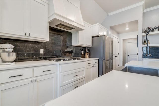 4145 Thunderhead Rd, Norman, OK 73072 - kitchen featuring stainless steel appliances, ornamental molding, decorative backsplash, white cabinetry, and custom exhaust hood