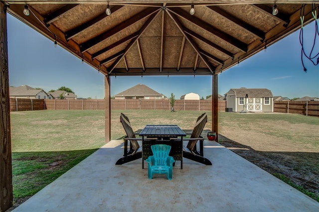 4145 Thunderhead Rd, Norman, OK 73072 - fenced backyard with a patio, a storage unit, and outdoor dining space