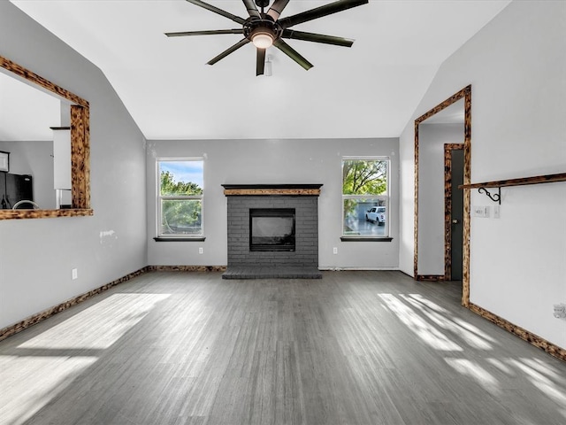 12506 SE 16th Ct, Choctaw, OK 73020 - unfurnished living room with vaulted ceiling, wood finished floors, ceiling fan, and a brick fireplace