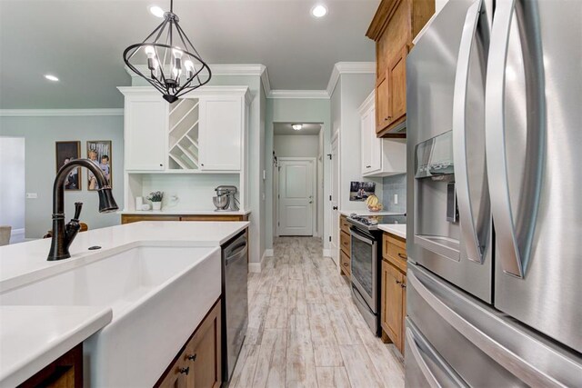 8350 Red Feather, Arcadia, OK 73007 - kitchen with crown molding, hanging light fixtures, appliances with stainless steel finishes, and a sink