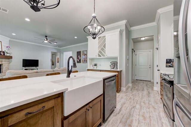 8350 Red Feather, Arcadia, OK 73007 - kitchen featuring brown cabinetry, appliances with stainless steel finishes, pendant lighting, and a sink