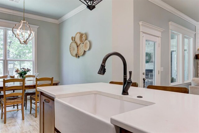8350 Red Feather, Arcadia, OK 73007 - kitchen featuring a sink, an inviting chandelier, light countertops, ornamental molding, and hanging light fixtures