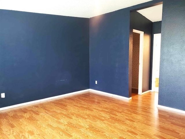 unfurnished room featuring baseboards and wood finished floors