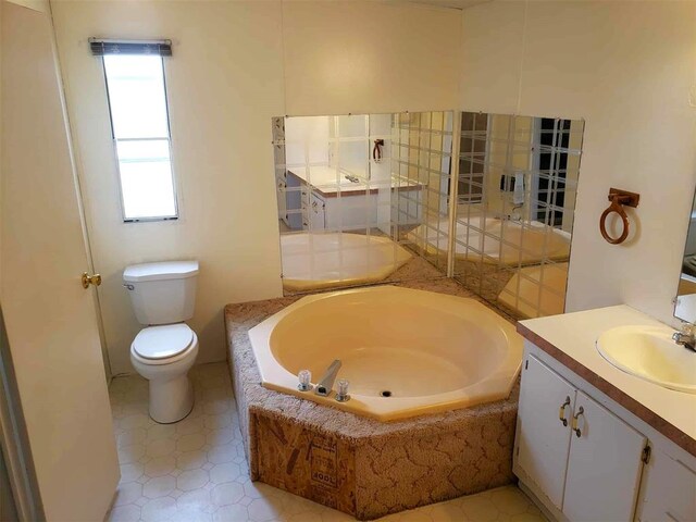 full bath with vanity, a garden tub, and toilet