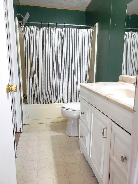 full bathroom with toilet, shower / tub combo, and vanity