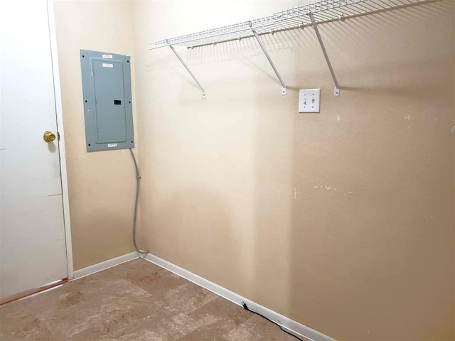 laundry area with baseboards and electric panel