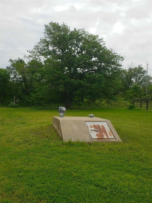 entry to storm shelter featuring a lawn