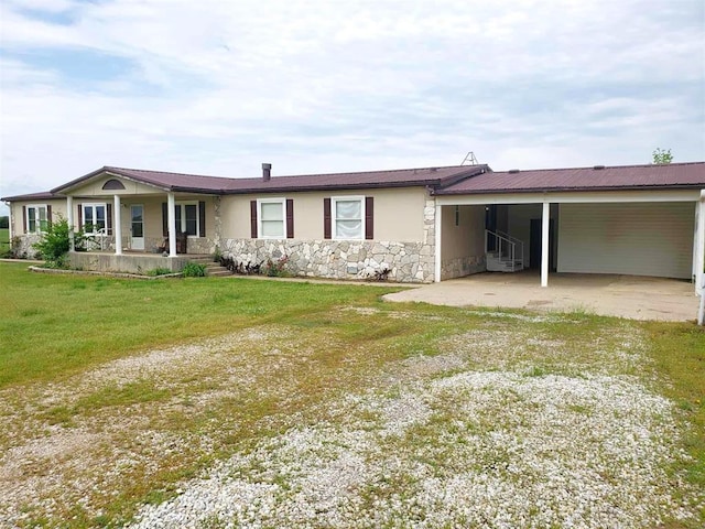 view of front facade featuring a front lawn, stone siding, an attached carport, a porch, and driveway