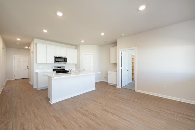 kitchen featuring light wood-style flooring, light countertops, baseboards, appliances with stainless steel finishes, and recessed lighting