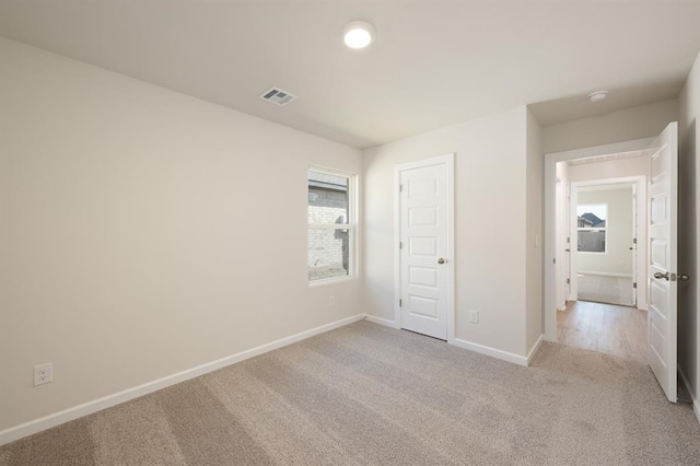 unfurnished bedroom featuring carpet floors, visible vents, and baseboards