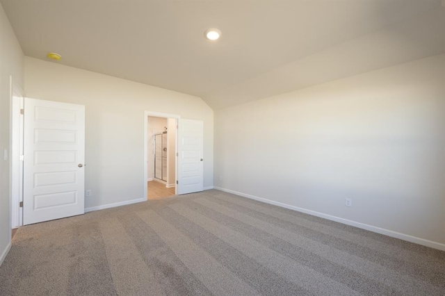 spare room featuring lofted ceiling, baseboards, carpet, and recessed lighting